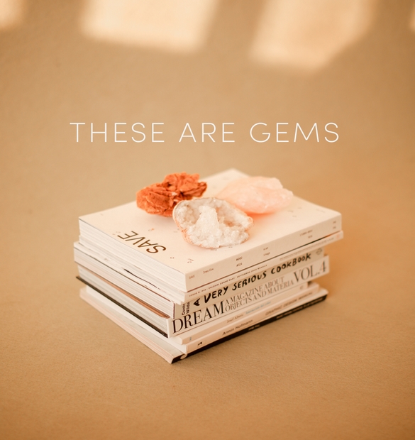 Livres empilés avec l’inscription. “These are gems” – Mise en scène poétique autour de la lecture et des trésors du quotidien