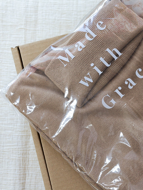 Haut beige Grace & Mila délicatement emballé dans un sachet plastique transparent. Présentation soignée et minimaliste, prêt à être découvert.